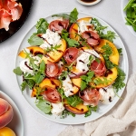 Salade de roquette aux pêches rôties, prosciutto et stracciatella Casa Azzurra