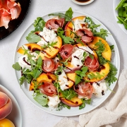 Salade de roquette aux pêches rôties, prosciutto et stracciatella Casa Azzurra