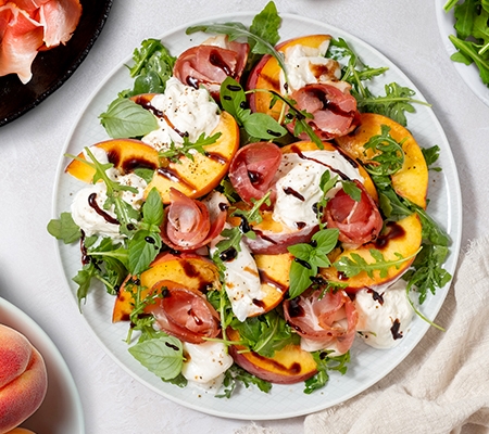 Salade de roquette aux pêches rôties, prosciutto et stracciatella Casa Azzurra